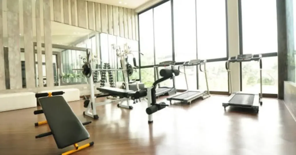 Modern gym with treadmills, weight benches, and a squat rack in a bright, spacious room